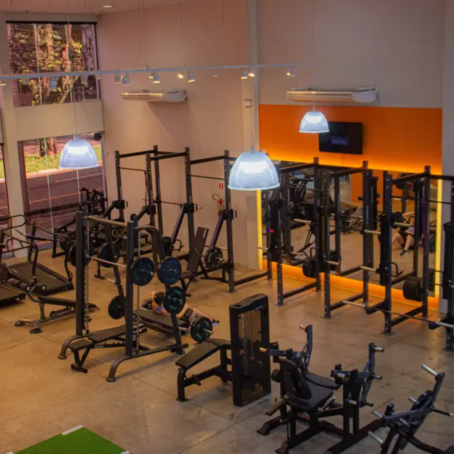 Academia moderna com equipamentos de musculação e cardio, ideal para personal training e treinos em grupo personalizados.