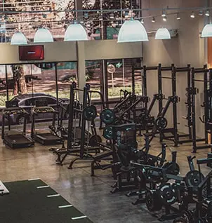 Academia moderna com equipamentos de musculação e área funcional para personal training e treinos em grupo personalizados.